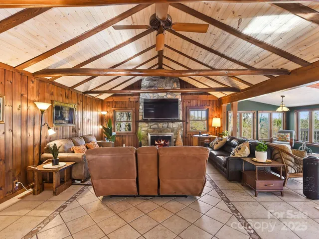 a living room with furniture a fireplace and a ceiling fan