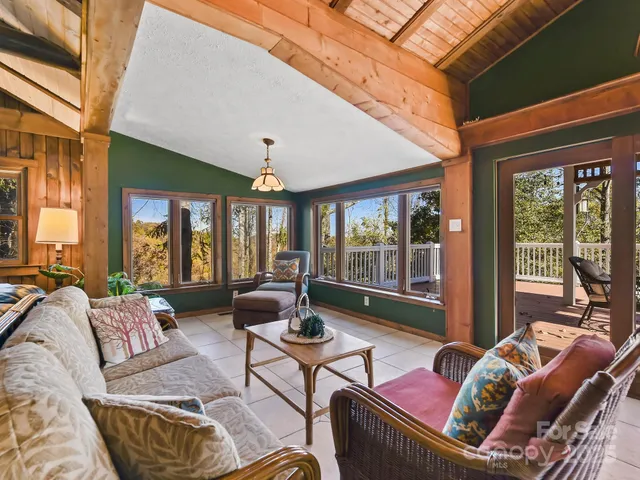 a living room with furniture and floor to ceiling windows