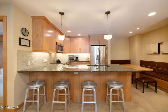 a kitchen with refrigerator and chairs