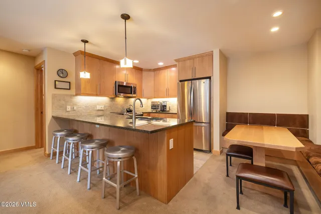 a kitchen with stainless steel appliances granite countertop a sink a stove and cabinets