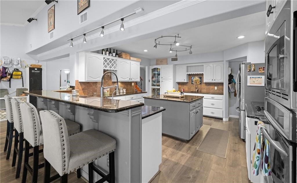 5337 Inverness Drive Corpus Christi, TX 78413 - Photo 11 of 32 a kitchen with stainless steel appliances kitchen island granite countertop a table chairs sink and cabinets