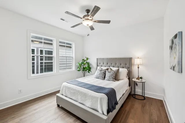 a bedroom with a large bed chandelier and a window