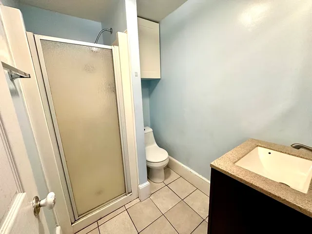 a bathroom with a granite countertop sink toilet and shower