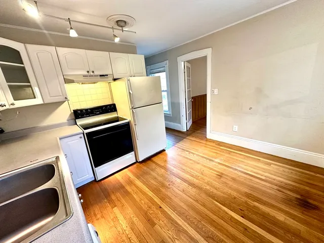 a view of a kitchen with wooden floor and electronic appliances