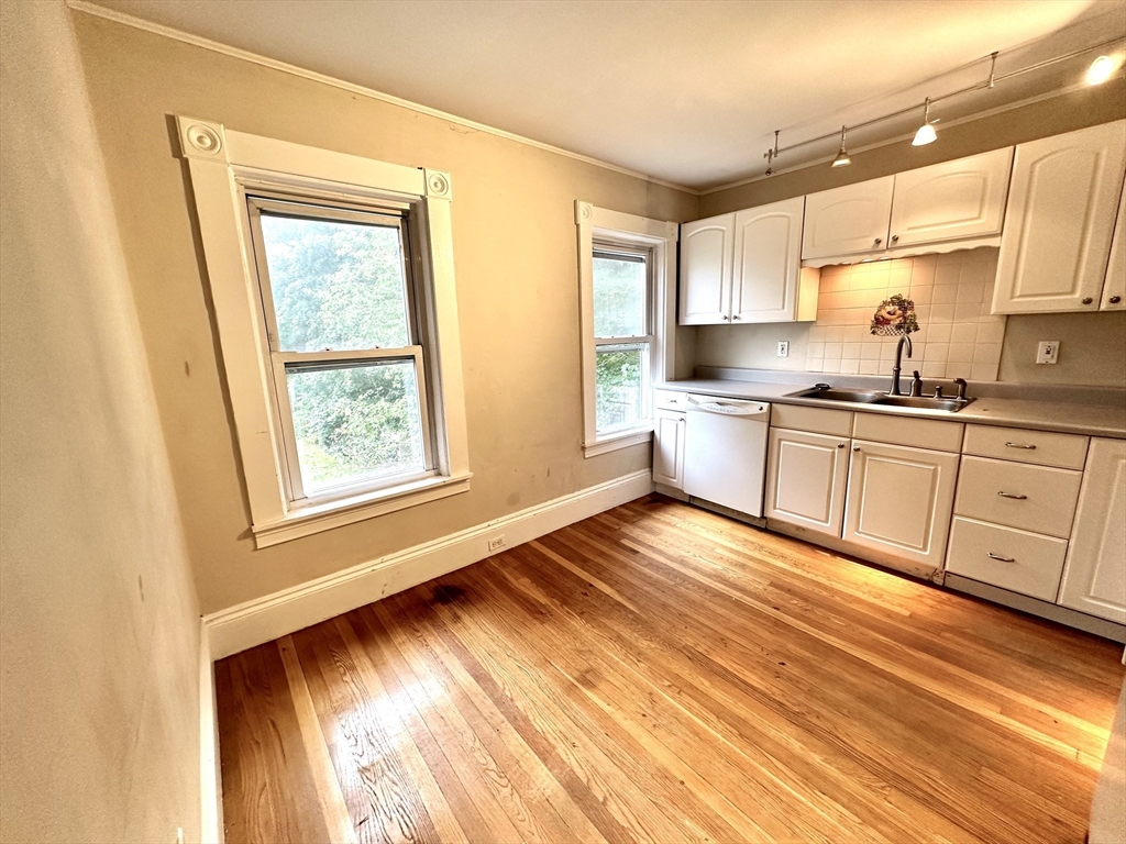 6 Grant Street, Unit 2 Natick, MA 01760 - Photo 5 of 15 a view of a kitchen with wooden floor and stainless steel appliances