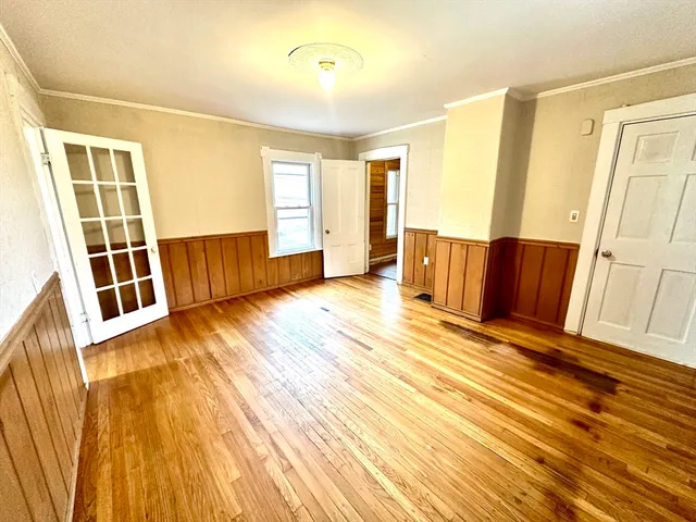a view of a room with wooden floor and door