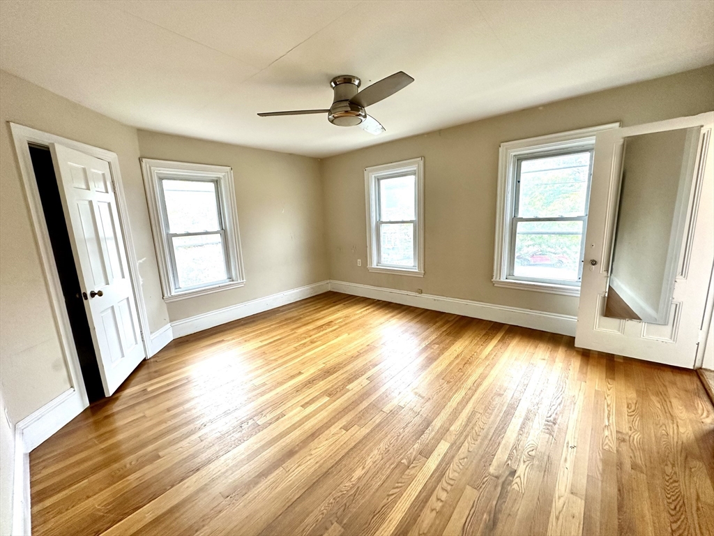 6 Grant Street, Unit 2 Natick, MA 01760 - Photo 9 of 15 a view of empty room with wooden floor and fan