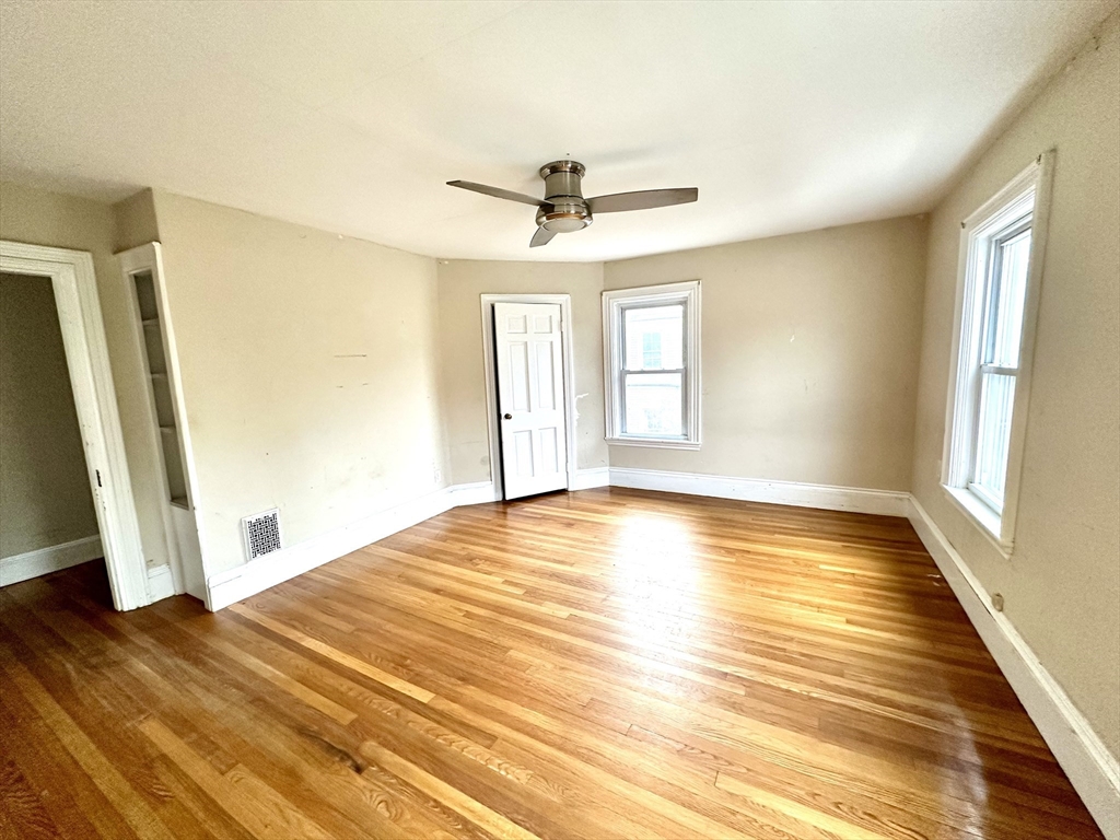 6 Grant Street, Unit 2 Natick, MA 01760 - Photo 10 of 15 a view of empty room with wooden floor and fan