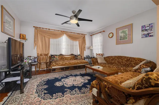 a living room with a bed and a flat screen tv