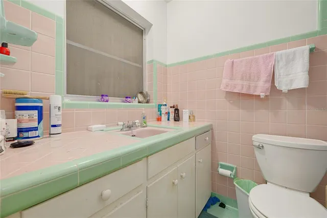 a bathroom with a sink a toilet and a mirror