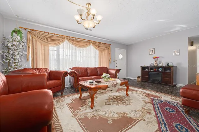 a living room with furniture a chandelier and a table