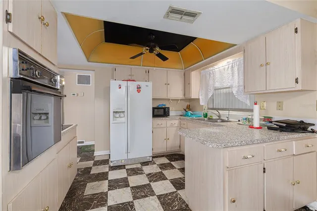 a kitchen with a sink a refrigerator and cabinets