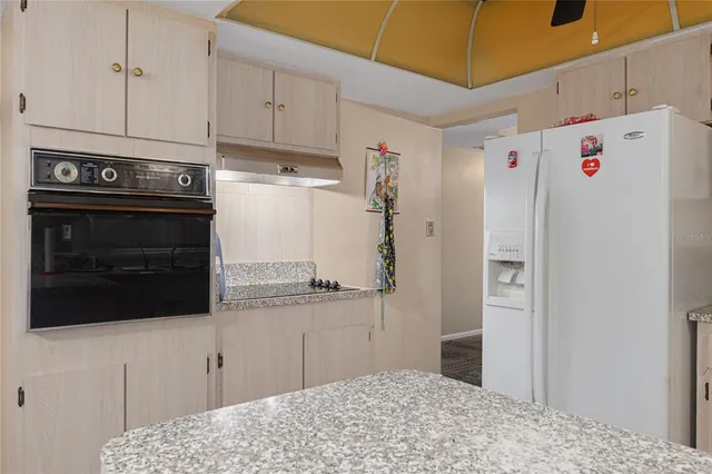 a kitchen with stainless steel appliances kitchen island a refrigerator sink and cabinets