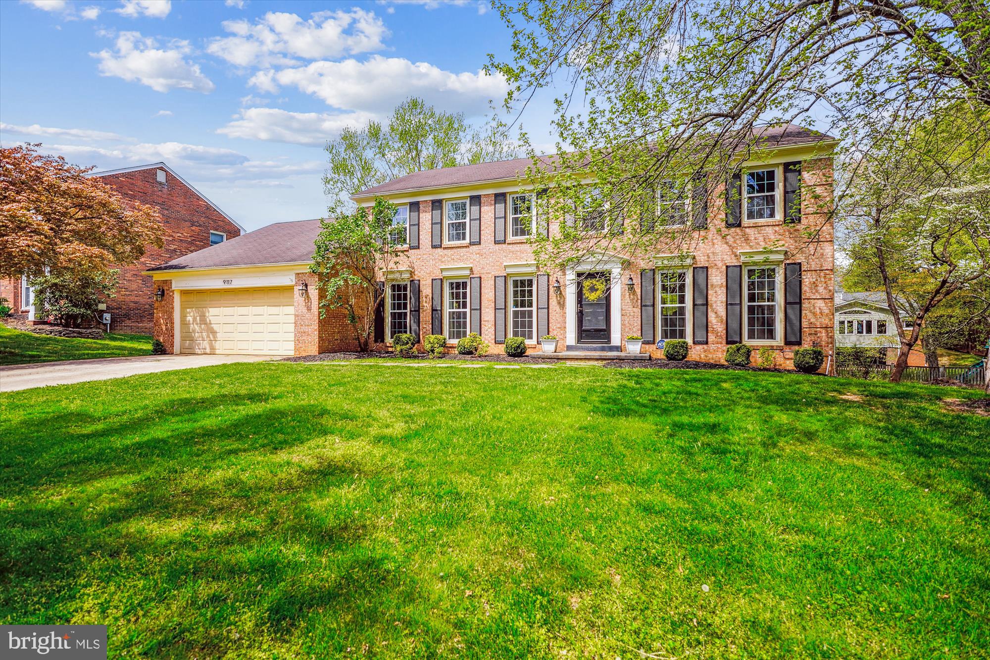9117 Paddock Lane Potomac, MD 20854 - Photo 2 of 69 a front view of a house with a garden and trees