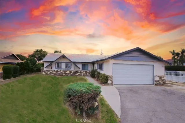 a view of a house with a yard and potted plants