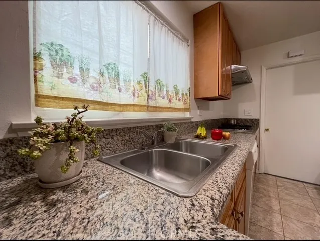a view of empty room with kitchen and window