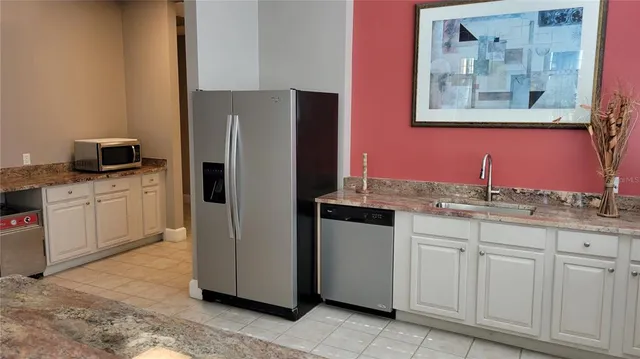 a kitchen with stainless steel appliances granite countertop a refrigerator and a sink