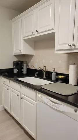 a kitchen with white cabinets and a sink
