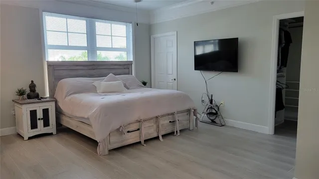 a bedroom with a bed and a flat screen tv