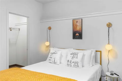 a bedroom with a bed and a lamp with the view of a small room