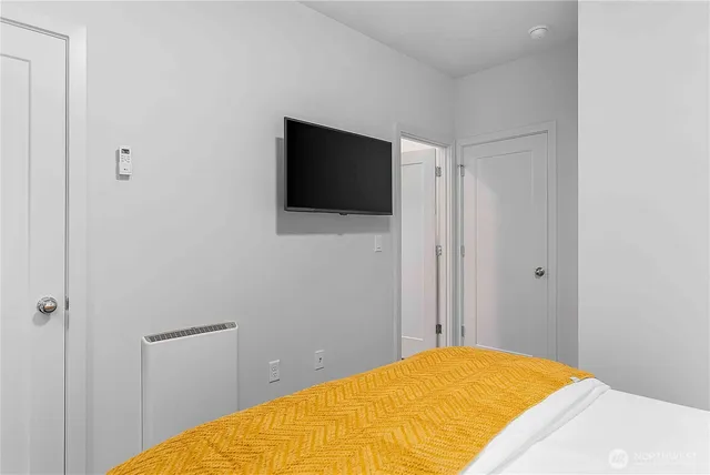 a bedroom with a bed and a flat screen tv