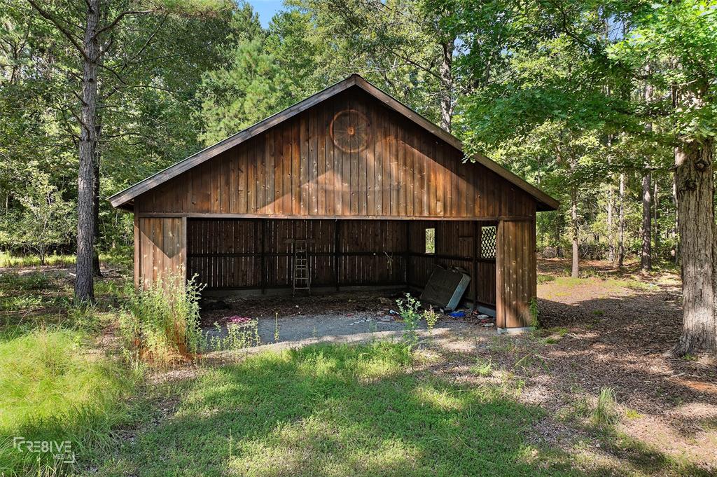 356 Cottage Grove Road Benton, LA 71006 - Photo 12 of 15 a view of backyard with wooden fence and a large tree