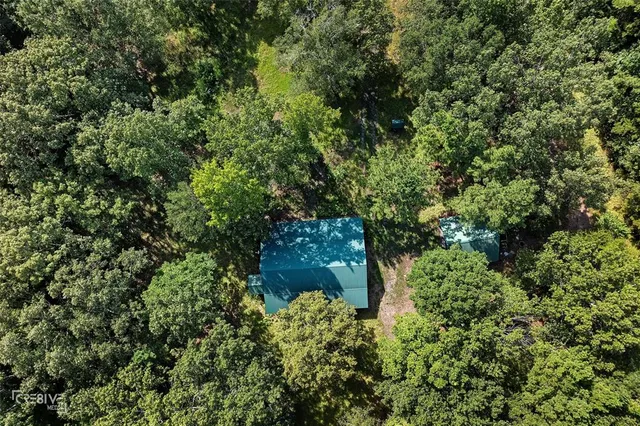 a view of a small house with wooden fence