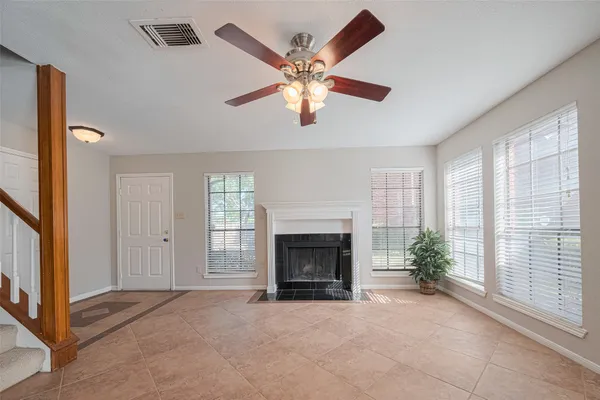 a view of a livingroom with a fireplace and a chandelier fan