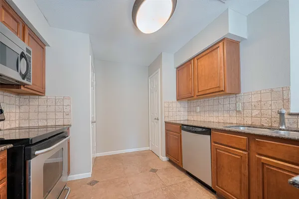a kitchen with stainless steel appliances granite countertop a sink and a stove