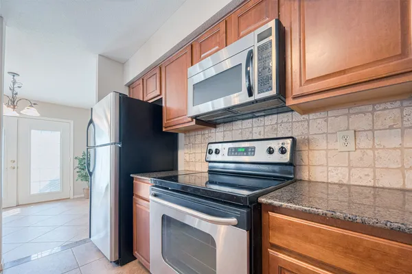 a kitchen with stainless steel appliances granite countertop a refrigerator and a stove