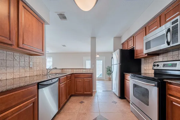 a kitchen with stainless steel appliances granite countertop a sink stove and refrigerator