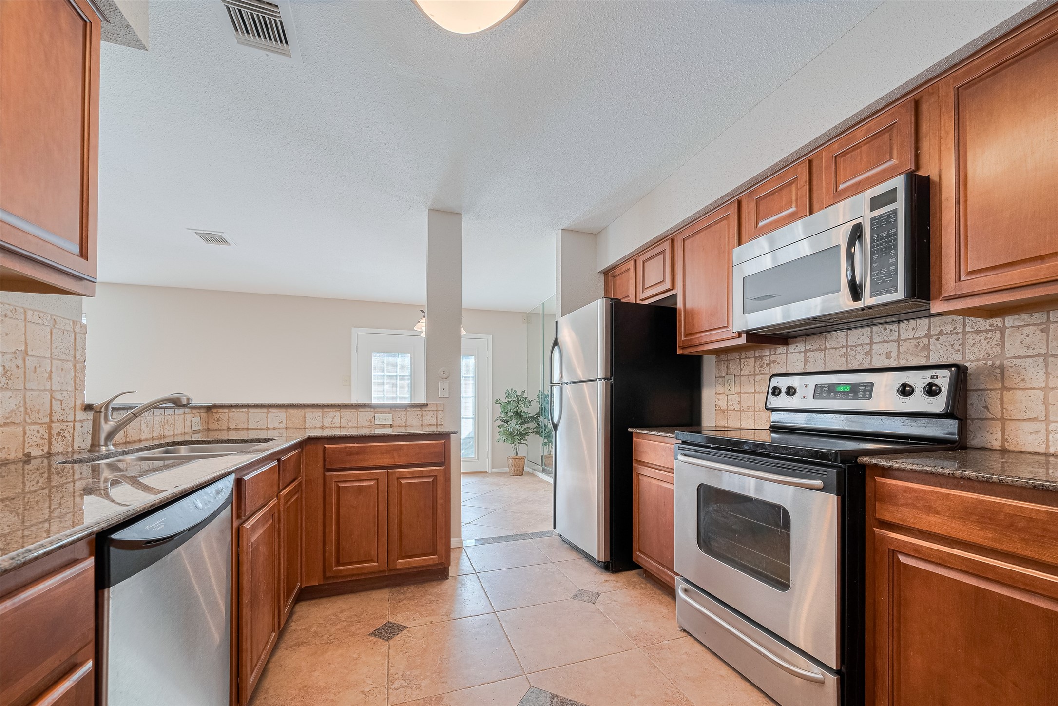 2211 South Kirkwood Road, Unit 19 Houston, TX 77077 - Photo 20 of 39 a kitchen with stainless steel appliances granite countertop a stove a sink and a microwave