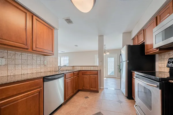 a kitchen with stainless steel appliances granite countertop a sink stove and refrigerator