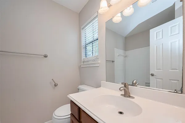 a bathroom with a sink vanity mirror and toilet