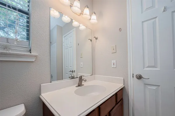 a bathroom with a sink a toilet and a mirror