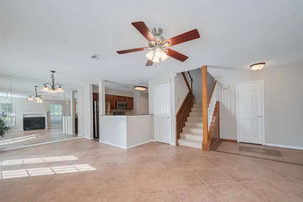 a view of a livingroom with a staircase and a ceiling fan