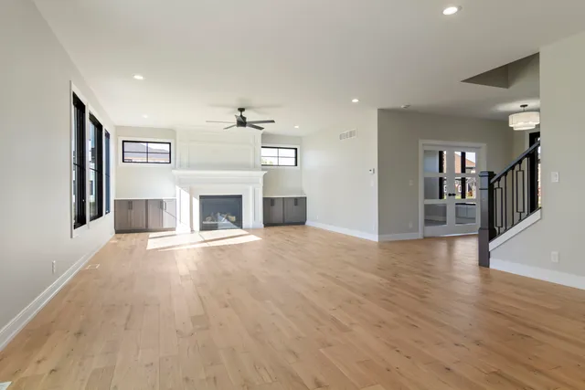 a view of a livingroom with a fireplace wooden floor and staircase