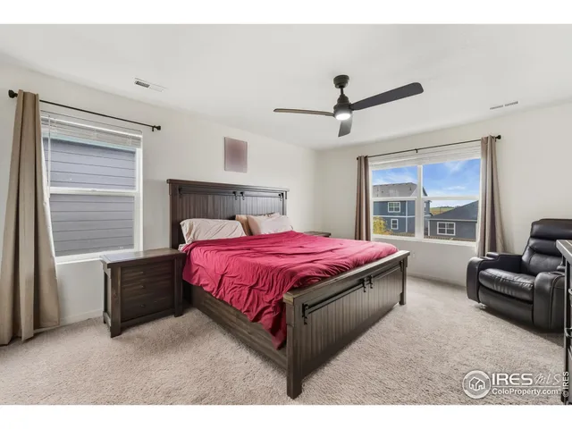 a spacious bedroom with a bed and glass walk in closet