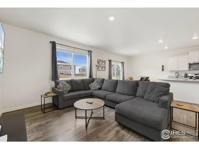 a living room with furniture and a view of kitchen