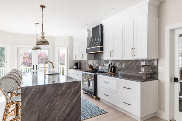 a kitchen with stainless steel appliances granite countertop a stove top oven a sink a counter space and cabinets