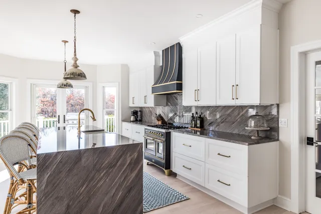 a kitchen with stainless steel appliances granite countertop a stove top oven a sink a counter space and cabinets