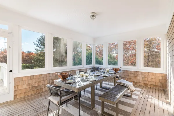 a view of a dining room with furniture large windows and wooden floor