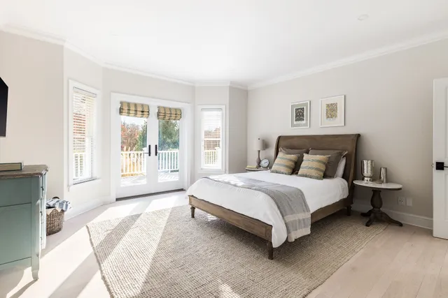 a bedroom with a bed lamp and a large window