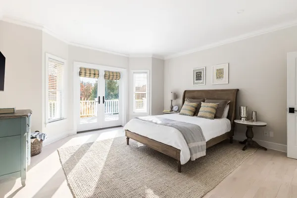 a bedroom with a bed lamp and a large window