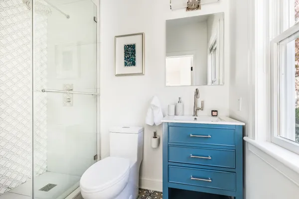 a bathroom with a toilet a sink a vanity and mirror