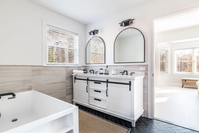 a bathroom with a sink mirror and a bathtub