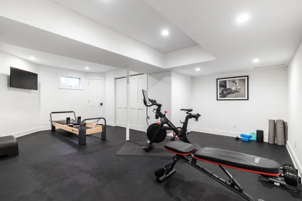 a living room with furniture gym equipment and a flat screen tv