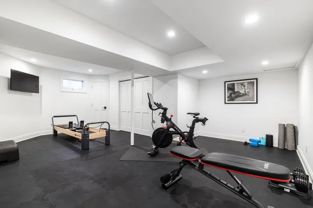 a living room with furniture gym equipment and a flat screen tv
