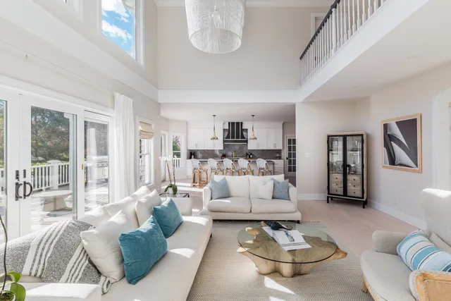 a living room with furniture and a dining table with wooden floor