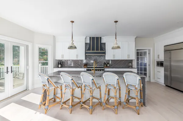 a kitchen with white cabinets and refrigerator